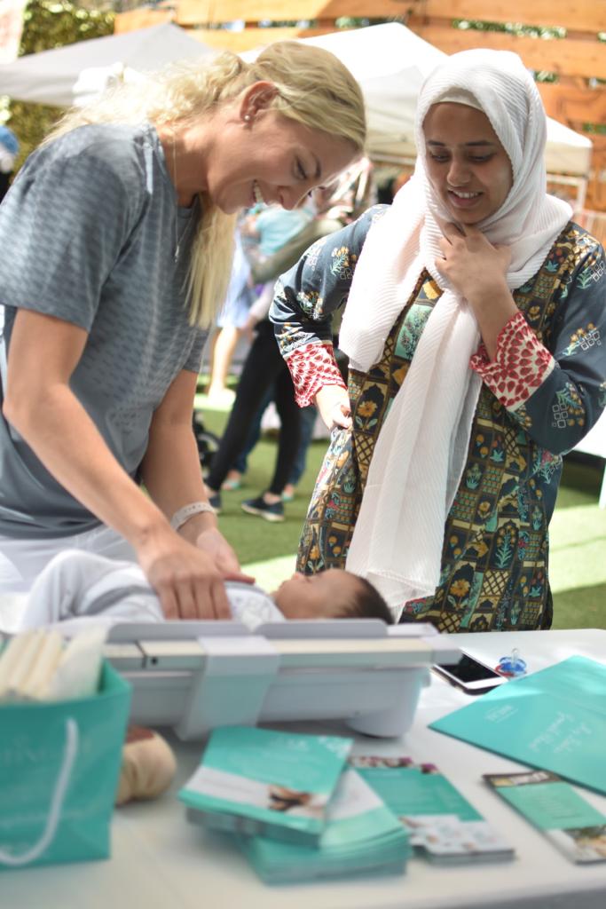 A Nightingale nurse and a parent with a baby at a Nightingale event in Dubai